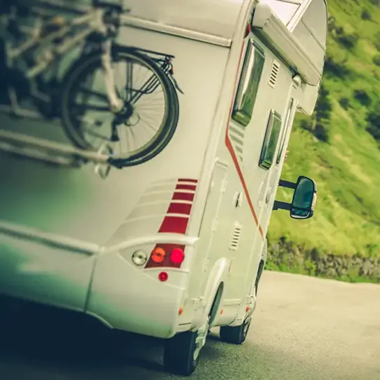 Rear view of a modern motorhome with a bike rack and bicycles, highlighting exterior RV accessories from B&S RV Supply.